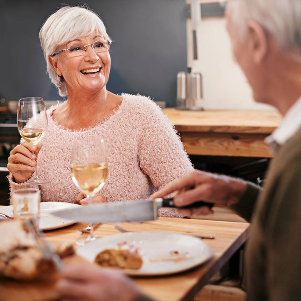 Ζευγάρι ηλικιωμένων, φαγητό και αλκοόλ για την αγάπη στο τραπέζι, συζήτηση και υγιεινό γεύμα στο σπίτι για την επέτειο. Οι άνθρωποι, συγκόλληση και το φαγητό μαζί το Σαββατοκύριακο, χαλαρώστε και μιλώντας για ρομαντικό δείπνο ημερομηνία. - Φωτογραφία, εικόνα