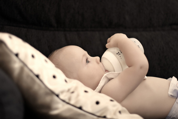 Un bebé de seis meses bebiendo de su biberón
 - Foto, Imagen