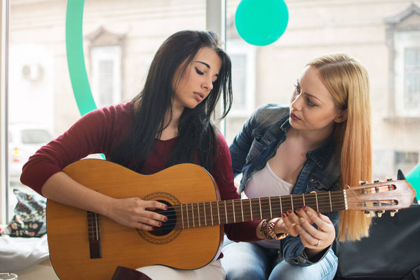 дівчина навчає свого друга грати на гітарі
. - Фото, зображення