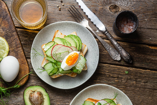 Breakfast. Sandwich with cream cheese, avocado, cucumber and poached egg - Photo, Image