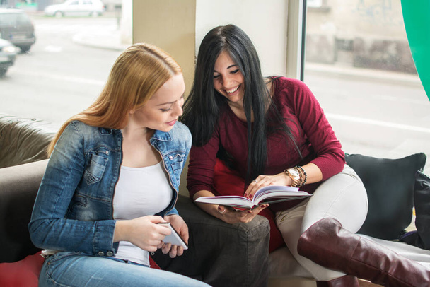 Dos lindas alumnas leyendo libro. - Foto, Imagen