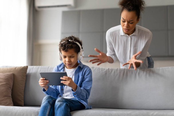 Mãe expressando preocupação com filhos uso de tablet com fones de ouvido - Foto, Imagem