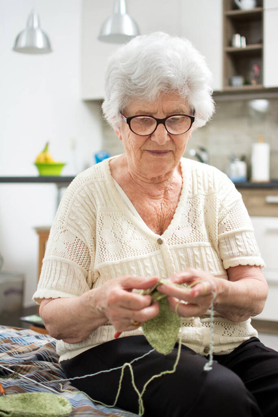 Mujer mayor tejiendo en casa
. - Foto, imagen
