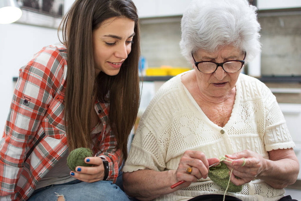 Nieta aprendiendo a tejer de su abuela. - Foto, Imagen