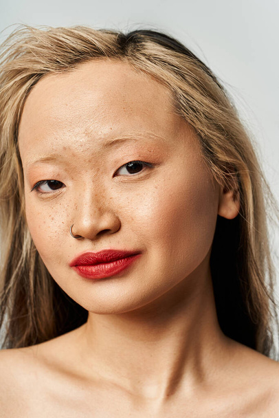 Asyalı kadın dalgalı saçlar ve kalın kırmızı dudaklarla cazibe saçar.. - Fotoğraf, Görsel