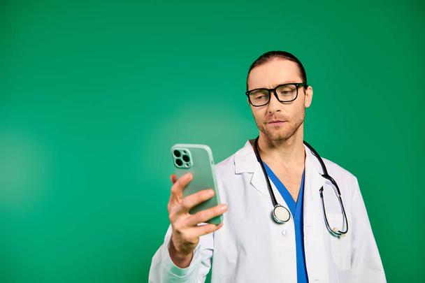 Schöner Arzt im weißen Gewand, Handy in der Hand, mit Stethoskop. - Foto, Bild