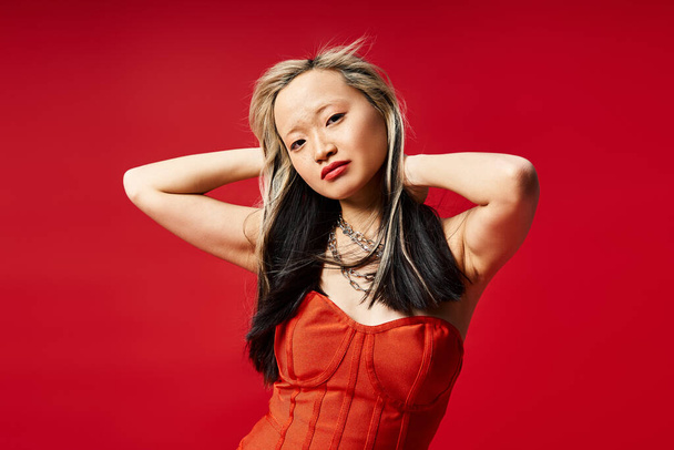 Ázsiai nő feltűnő piros ruha pózol elegánsan. - Fotó, kép