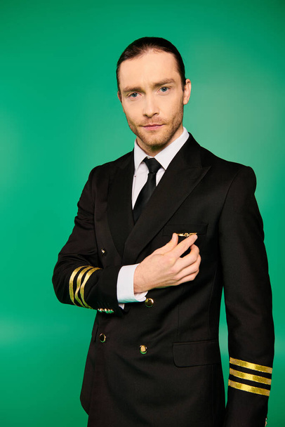 piloto masculino bonito em um terno e gravata posando em um pano de fundo verde. - Foto, Imagem
