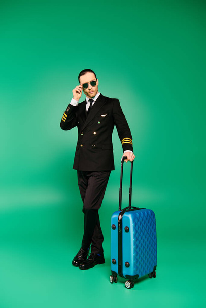 Handsome pilot in black suit and sunglasses holding a briefcase. - Photo, Image