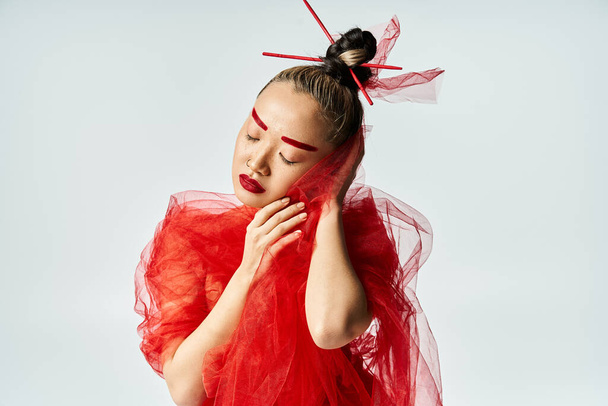 Азиатка в ярком красном платье и вуаль изящно позирует. - Фото, изображение