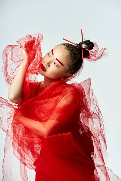 Азіатська жінка в червоній сукні, завіса навколо шиї, вражає позу. - Фото, зображення