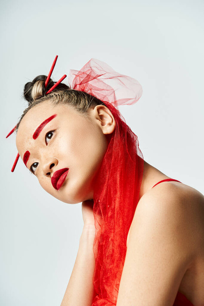 Kırmızı makyajlı ve saçlı büyüleyici Asyalı kadın canlı poz veriyor. - Fotoğraf, Görsel