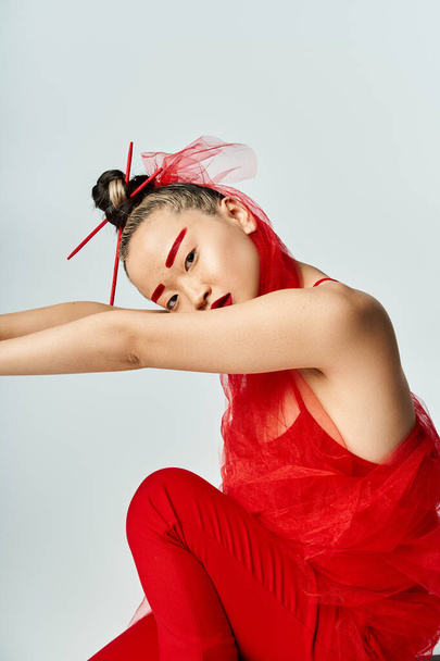 Atraktivní asijská žena v pulzujících červených šatech pózující sebevědomě pro obrázek. - Fotografie, Obrázek