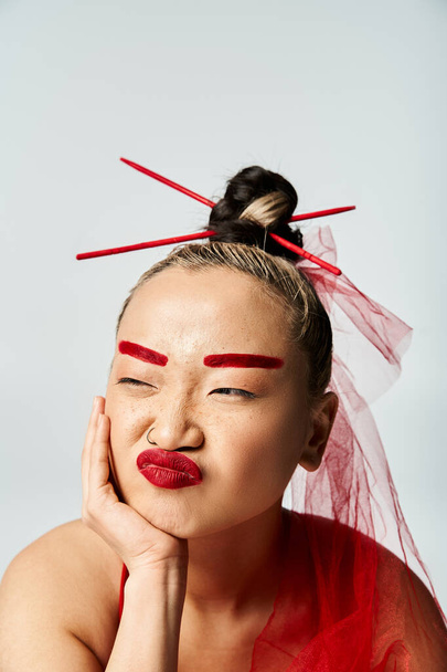 Asiatin in lebendiger Kleidung, geschmückt mit rotem Make-up und Schleier. - Foto, Bild