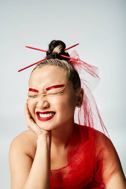 Asiatin mit rotem Make-up und Kopftuch posiert anmutig. - Foto, Bild