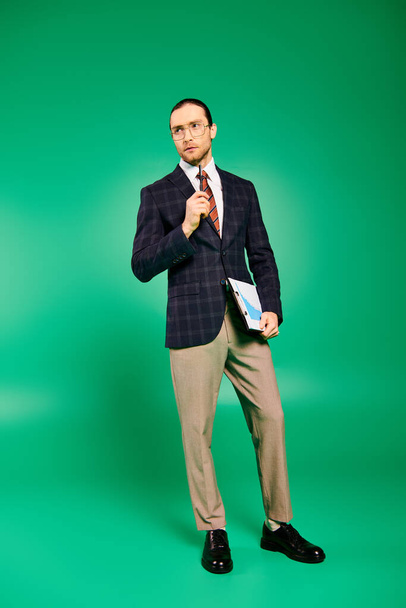Handsome businessman in a chic suit strikes a confident pose against a vibrant green backdrop. - Foto, immagini