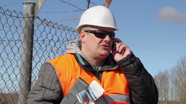 Инженер с банкнотами евро разговаривает по мобильному телефону
 - Кадры, видео