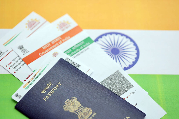 Indiase Aadhaar kaart van de Unieke Identificatie Autoriteit van India en paspoort op Indiase vlag close-up - Foto, afbeelding
