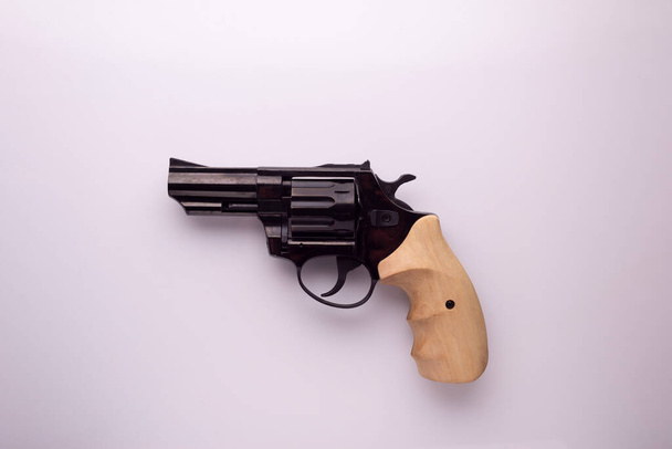 revolver nero con manico in legno su fondo bianco. - Foto, immagini