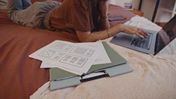 Καλλιεργημένη φωτογραφία της γυναίκας ελεύθερος επαγγελματίας ξαπλωμένη στο κρεβάτι, ενώ κάνει ετήσια έκθεση για το φορητό υπολογιστή στο σπίτι - Πλάνα, βίντεο