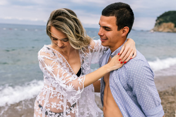 Felice giovane coppia ridendo e abbracciandosi sulla spiaggia - Foto, immagini