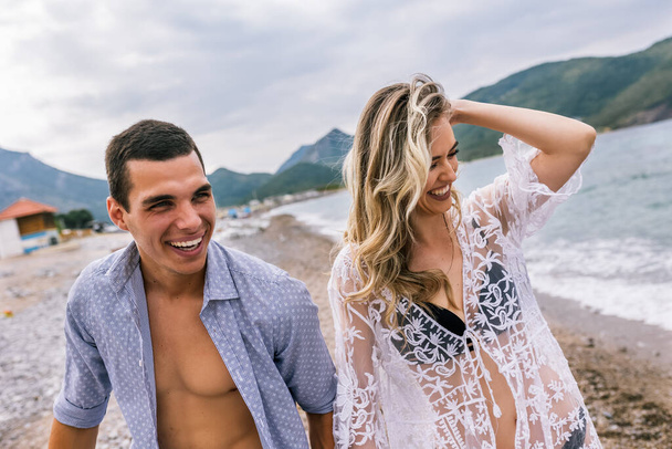 Šťastný mladý pár smích a objímání na pláži - Fotografie, Obrázek