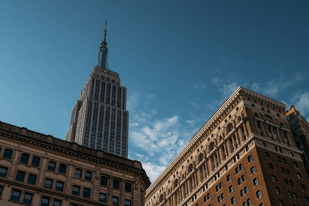 Słońce rzuca majestatyczny blask na kultowy Empire State Building. - Zdjęcie, obraz