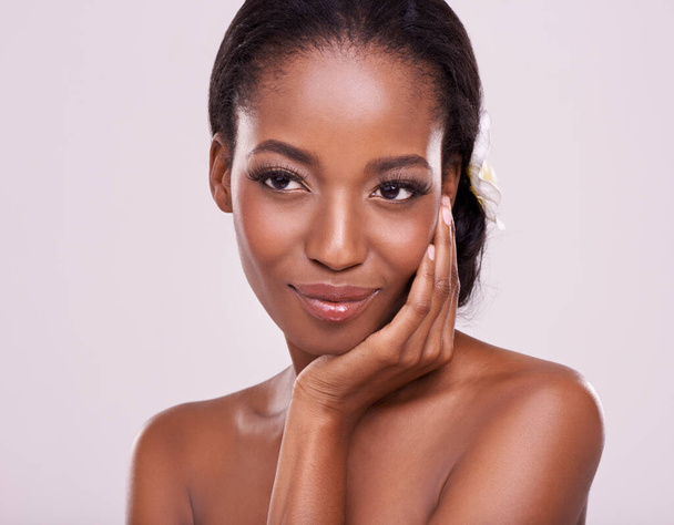 Woman, face and skincare for beauty in studio with cosmetics, natural glow and self care with happiness. Model, african person or smile for cosmetology, facial treatment or makeup on white background. - Photo, Image