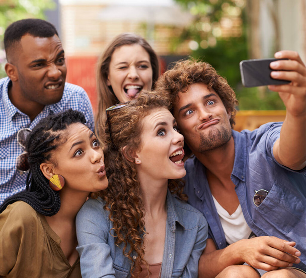 Vrienden, vrolijke en gekke selfie op de campus voor komedie, zorg en profielfoto om te updaten op social media. Studenten, diversiteit of mobiele app voor fotografie aan de universiteit of het geheugen samen in de buitenlucht. - Foto, afbeelding