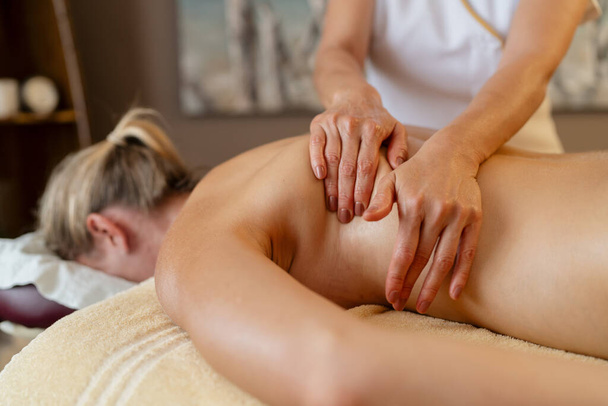 Hierontaterapeutti työskentelee naisen selässä kauneushoitolassa Wellness Hotel - Valokuva, kuva