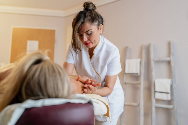 Gericht massage therapeut werkt aan vrouwelijke cliënt rug in een spa. schoonheidssalon Wellness Hotel Concept beeld - Foto, afbeelding