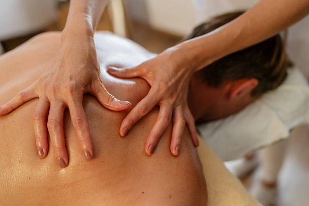 Close-up van een massagetherapeut die druk uitoefent op de rug van een cliënt. schoonheidssalon Wellness Hotel Concept beeld - Foto, afbeelding