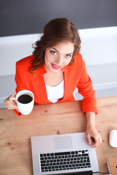 Mulher atraente sentada na mesa no escritório, trabalhando com computador portátil - Foto, Imagem