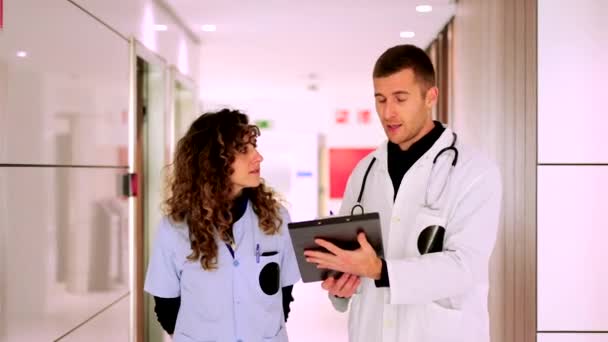 Médico y enfermera hablando en un pasillo del hospital - Imágenes, Vídeo