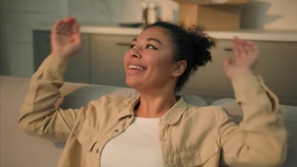 Afroamerikanerin glücklich zufrieden ethnische Mädchen Hausbesitzer fallen auf gemütliches Sofa entspannen Sie sich auf der Couch Umzug in neues Haus Mietwohnung Umzug Tag Umzug in eigenes Haus kaufen Wohnung Immobilien Hypothek - Filmmaterial, Video