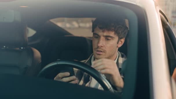 Pettynyt stressaantunut surullinen mies Valkoihoinen auto kuljettaja liikemies auton sisällä odottaa liikenneruuhkassa matkapuhelimella lue huonoja uutisia järkyttynyt tyytymätön menetys GPS navigointi tie ajo kaupungissa - Materiaali, video