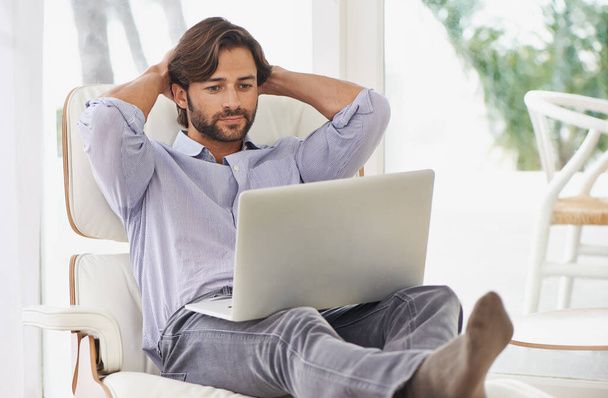 Businessman, relax and couch with laptop online for remote work, living room and home office for freelance job. Male person, social media and browsing or research on computer, sofa and smile. - Photo, Image