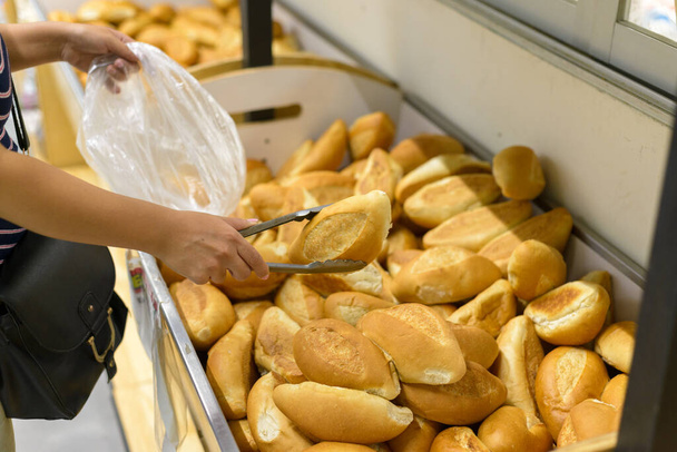 Osoba vybírající chléb v supermarketu. Stojan na chleba. - Fotografie, Obrázek