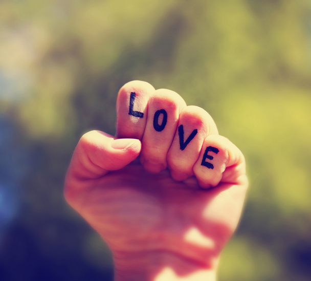 a fist with the word love written or tattooed on the fingers ton - Foto, imagen