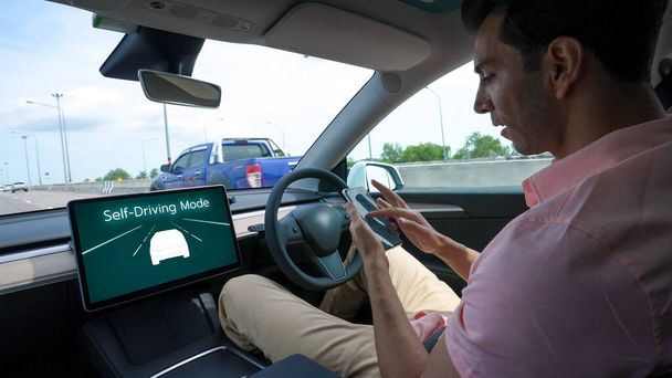 Selbstfahrendes Auto oder autonomes Fahrzeug fahren auf Schnellstraßen mit fahrerlosem System und Autopilot-Modus, so dass sich der Fahrer entspannen und auf das Smartphone konzentrieren kann, ohne die Sicherheit zu beeinträchtigen. Unvergänglich - Foto, Bild