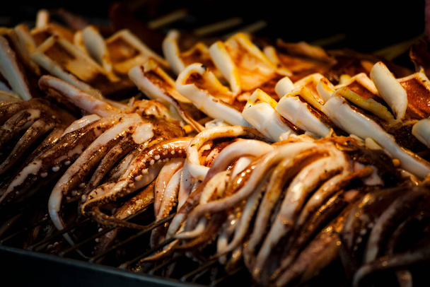  lulas frescas estão sendo grelhadas com uma perfeição dourada na churrasqueira - Foto, Imagem