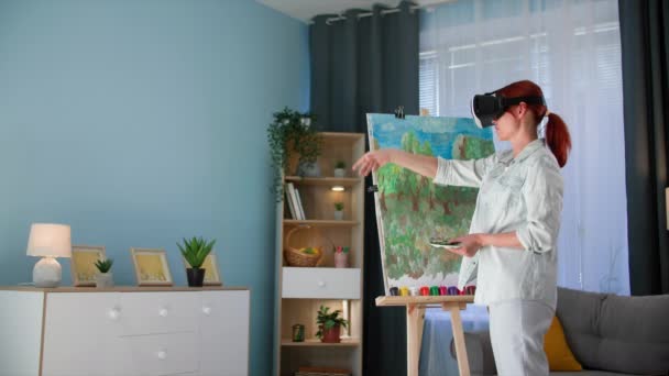 moderní technici, umělkyně ve virových brýlích kreslí obraz na plátno, zatímco stojí v místnosti - Záběry, video