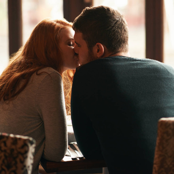 Çift, kafe 'de aşk ve öpüşme, romantizm veya dikiz aynasıyla sağlıklı bir ilişki için. Erkek, kadın ve restoranda şefkat, güven ve yıldönümü tatilinde güzel bir yemek.. - Fotoğraf, Görsel