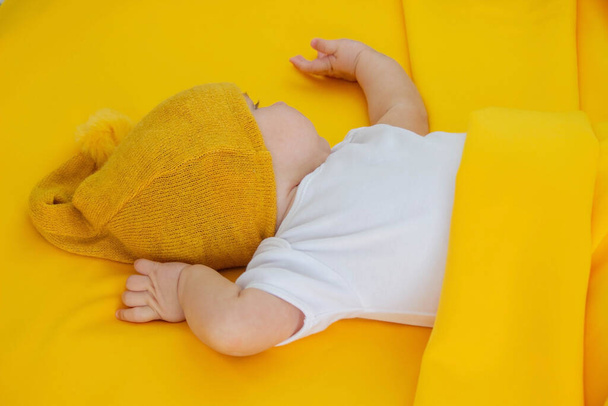 glimlachend meisje gaat slapen met een teddybeer op een gele achtergrond. kinderen - Foto, afbeelding