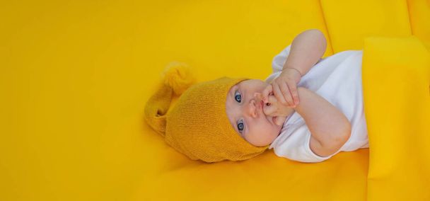 Gülümseyen bebek, sarı arka planda oyuncak ayıyla uykuya dalıyor. çocuklar - Fotoğraf, Görsel