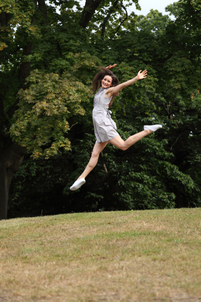 Jump for joy beautiful girl in countryside leaping - Foto, imagen