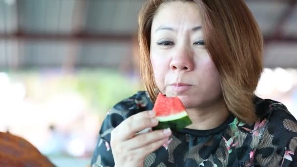 Szczęśliwy Asian żeński Ciesz się jedzenie dojrzały arbuz . - Materiał filmowy, wideo