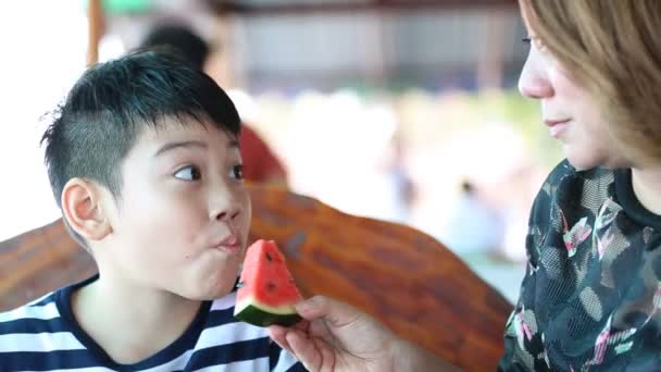 Boldog ázsiai gyermeket anyával élvezni eszik érett görögdinnye . - Felvétel, videó