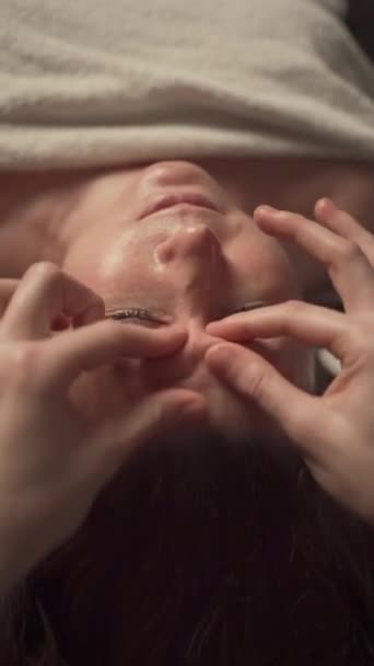 Donna matura che riceve un massaggio anti-invecchiamento facciale in un salone estetico. Trattamenti estetici e concetto di massaggio - Filmati, video