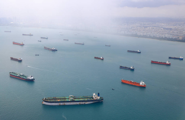 Widok z powietrza na Cieśninę Singapurską, Liniowiec oceaniczny, zbiornikowiec i statek towarowy z deszczem w Cieśninie Singapurskiej, Widok z samolotu. - Zdjęcie, obraz